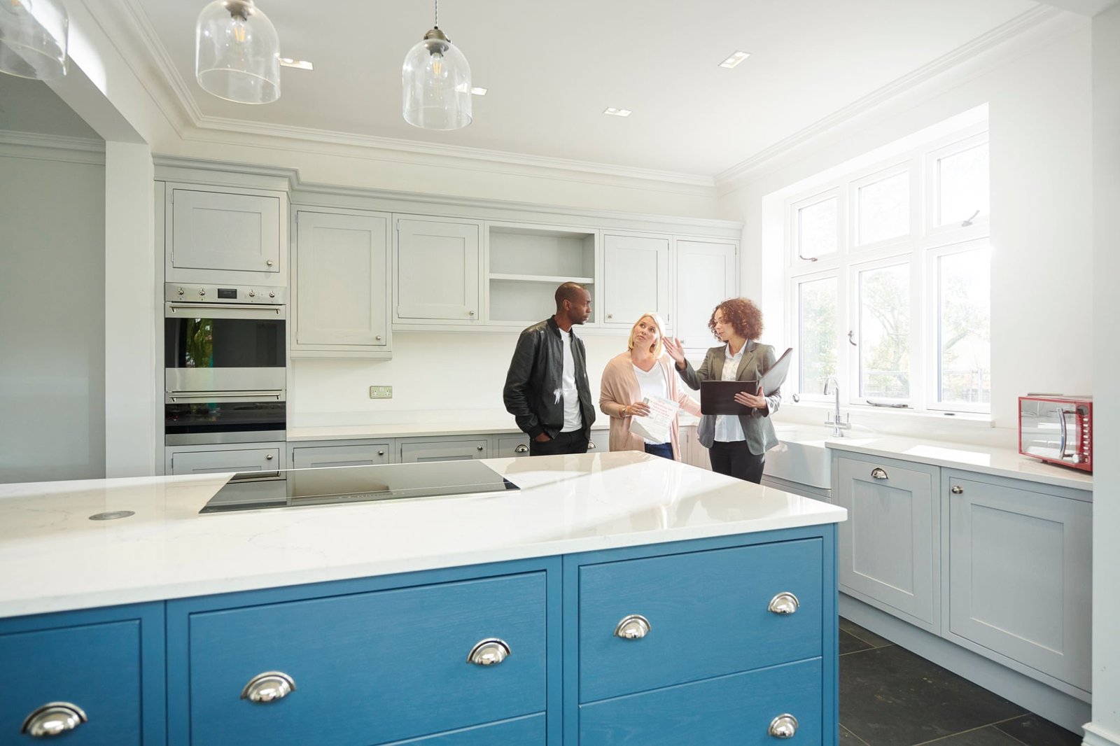 a saleswoman shows a couple around a home with new kitchen